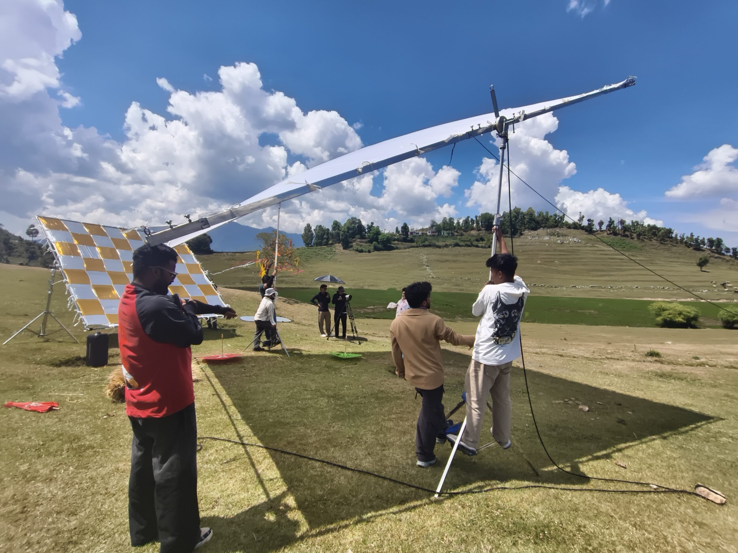 Mashakbeen crew setting up large reflector and lighting equipment on location